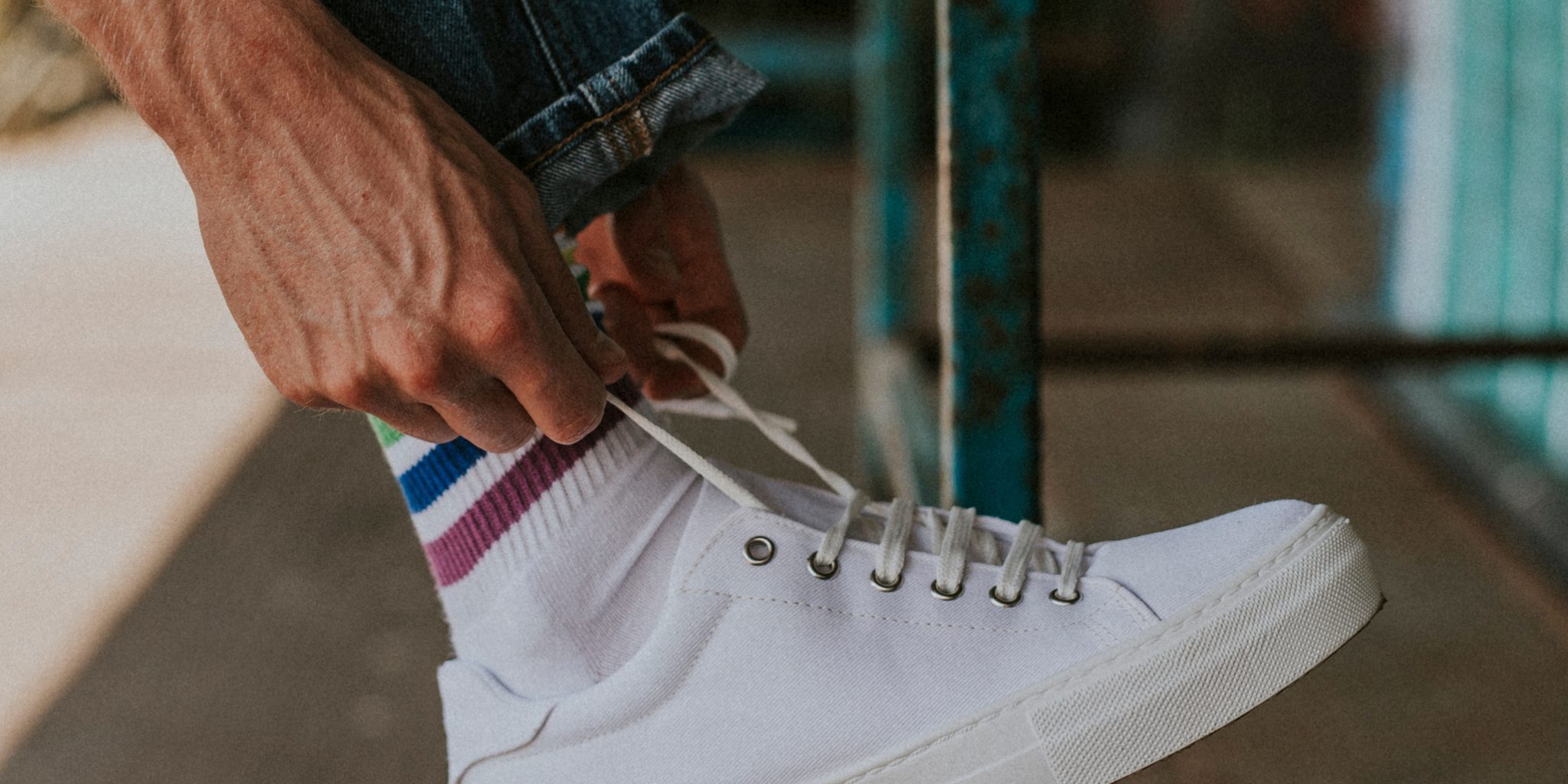 Man fixing lace on white sneaker