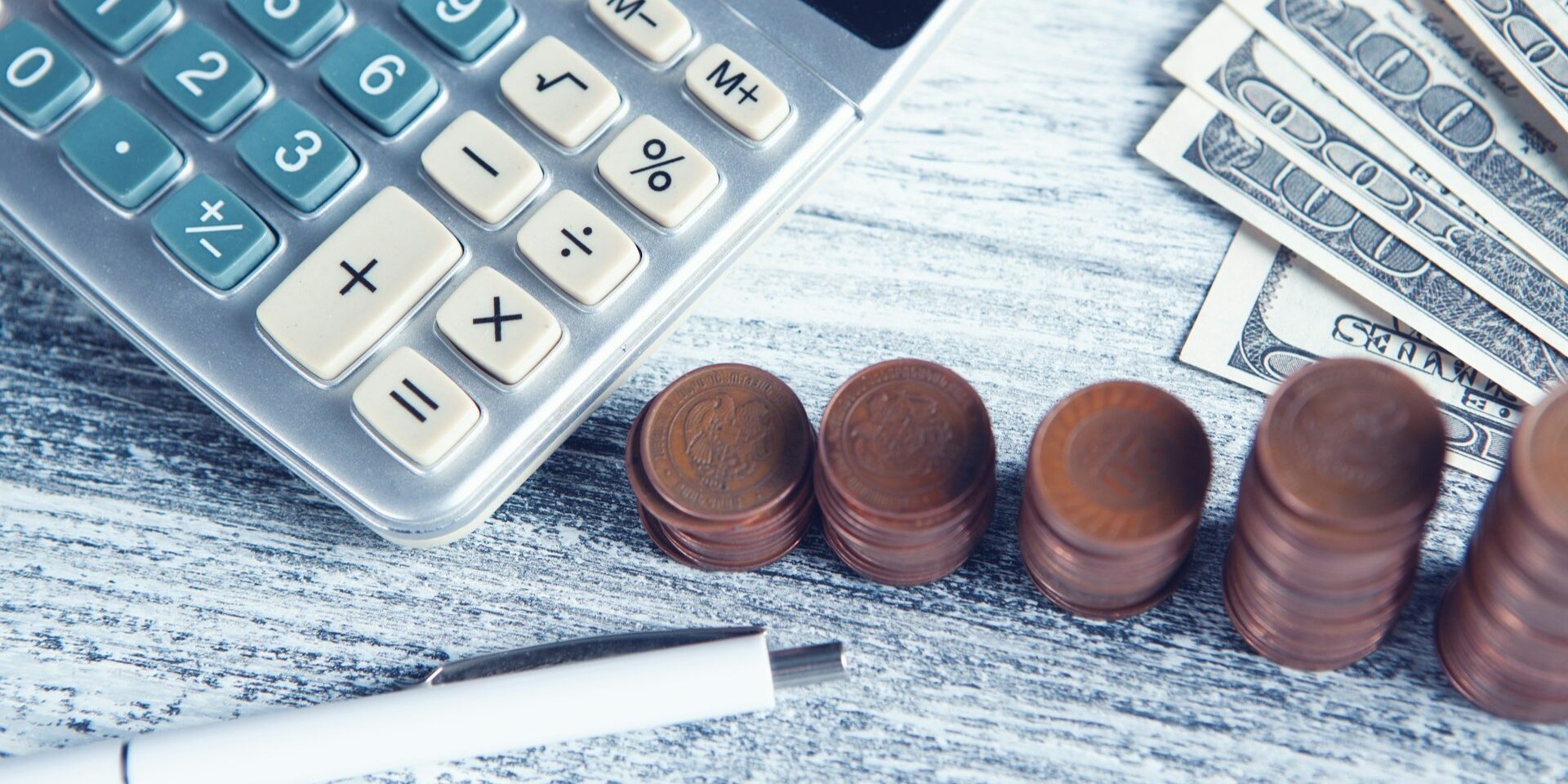 Overzicht van calculator, munten en contant geld bij het maken van financiële keuzes