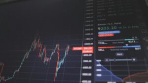 Grafiek op scherm met koersschommelingen bij financiële keuzes maken en investeren